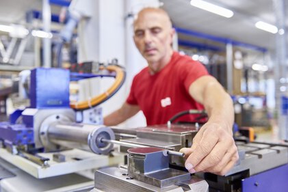 Arbeiten an einer Rohrbiegemaschine zur Herstellung von Kühlschlangen